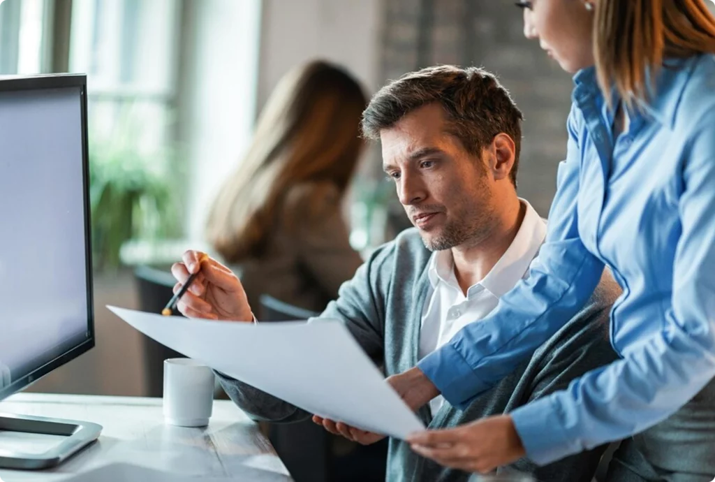 HR professionals reviewing documents together at a desk in a modern office